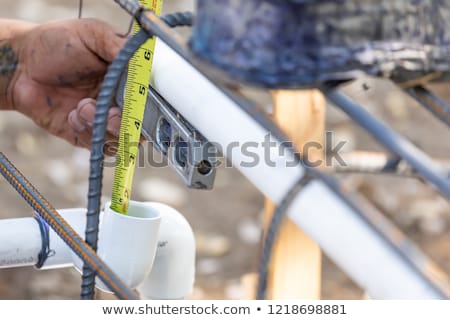 Foto stock: Plumber Using Level While Installing Pvc Pipe At Construction Si