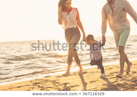 Foto d'archivio: Happy Young Family Have Fun On Beach Run And Jump