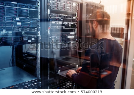 Stock photo: Young It Engeneer In Datacenter Server Room