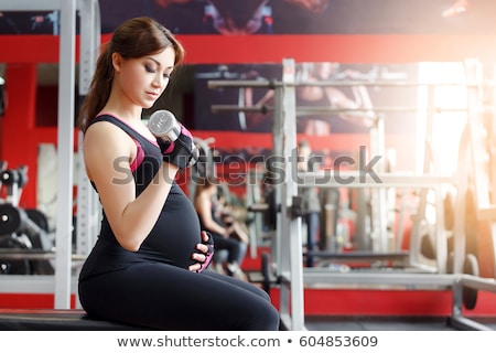 Stok fotoğraf: Pregnant Women With Sports Equipment In Gym