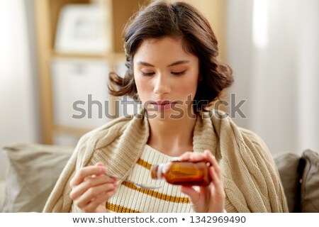 Zdjęcia stock: Sick Woman With Antipyretic Or Cough Syrup At Home