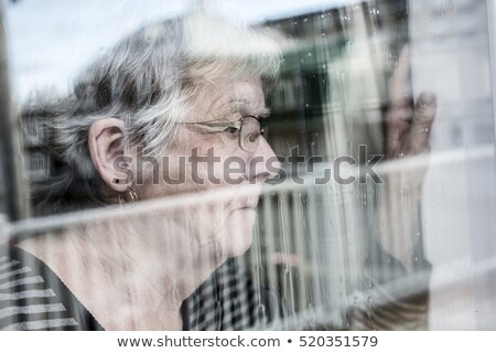 Zdjęcia stock: Senior Woman Looking Out Through A Window Like Depress