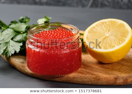 Stock photo: Caviar Red In A Glass Jar With Lemon And Parsley