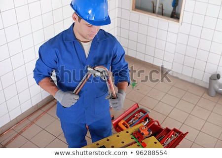 [[stock_photo]]: Plumber Bending Copper Pipe