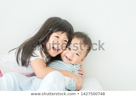 Foto stock: Brother And Sister Relaxing Together In Bed