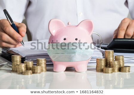 Stock fotó: Piggybank With Face Mask Near Accountant