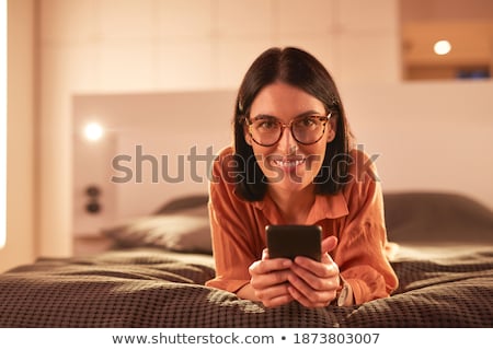 ストックフォト: Happy Businesswoman With Smartphone Lying In Bed