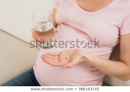 Сток-фото: Pregnant Woman Holding Glass Of Water And Vitamin Pill