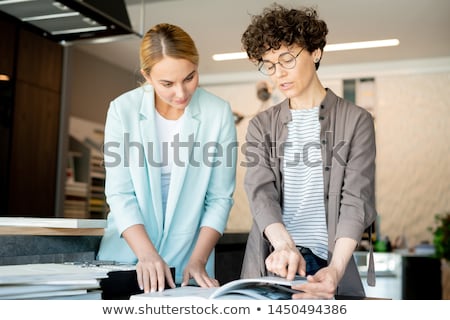 Stock fotó: Young Creative Designer Pointing At Page Of Catalogue While Helping Client