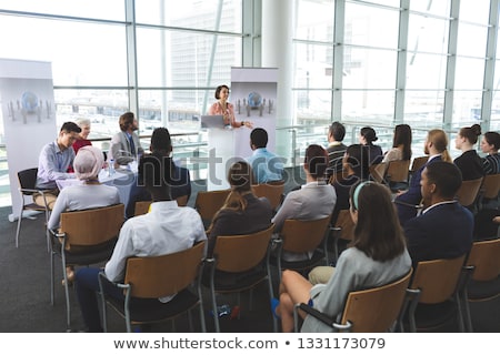 Сток-фото: High Angle View Of Mixed Race Businesswoman Speaking In Front Of Business People Sitting At Seminar