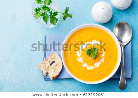 Stok fotoğraf: Pumpkin And Carrot Soup With Cream And Parsley On Blue Stone Background