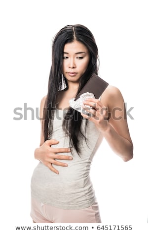 Zdjęcia stock: Woman Touching Her Abdomen While Looking At Chocolate