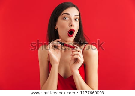 Zdjęcia stock: Excited Woman Posing Isolated Holding Lip Gloss Doing Makeup