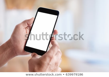Foto stock: Cheerful Young Casual Man Holding Mobile Phone