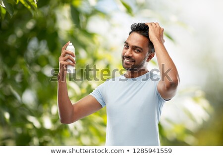 Foto stock: Man Applying Hair Spray Over Natural Background