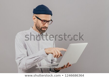 Stock photo: Professional Male Freelancer Makes Project Work Points With Index Finger At Screen Of Laptop Comput