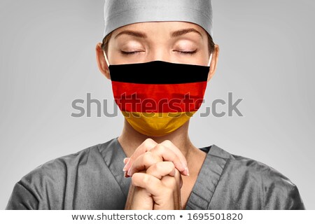 German Doctor Praying For Help With Germany Flag On Surgical Mask Young Woman Medical Needing Ppe H Zdjęcia stock © Maridav