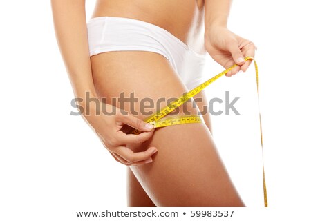 Stock photo: Woman Measuring Her Thigh With A White Metric Tape