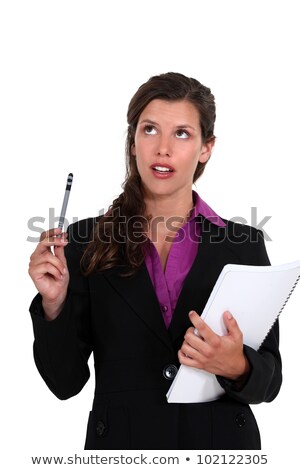 Foto stock: Young Businesswoman Looking Upwards With Notepad And Pen
