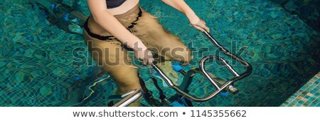 Stock photo: Smiling Woman On A Bicycle Simulator