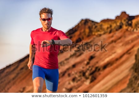 Stockfoto: Runner Checking Sports Watch In Summer Mountains On Trail