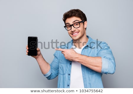 Stock fotó: Portrait Of A Smiling Young Man Holding Mobile Phone