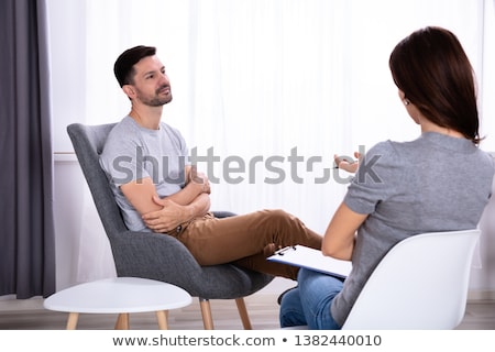 Foto d'archivio: Man Sitting On Chair Near Psychologist