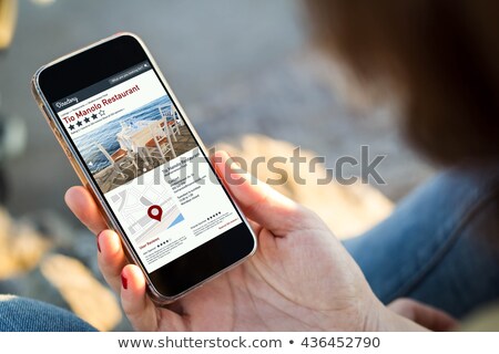 Stock photo: Woman Holding Phone With Online Rating In Restaurant