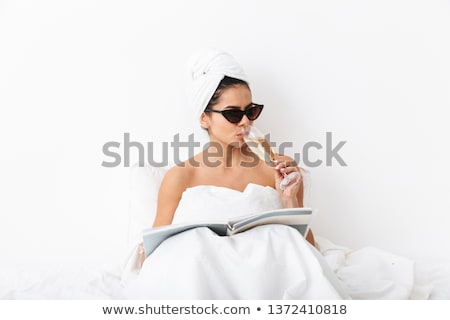 Zdjęcia stock: Beautiful Young Lady Lying In A Bed With A Glass Of Champagne