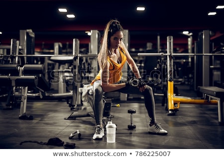 Stockfoto: Beautiful Slim Woman With Dumbbells Listening To Music While Exe