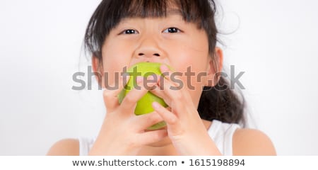 Foto stock: Cute Black Hair Little Girl Eating Green Apple