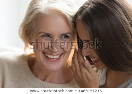 Stockfoto: Senior Mother Whispering To Adult Daughter At Home