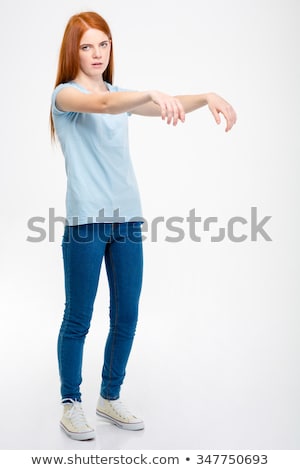 Stockfoto: Amusing Pretty Woman Standing And Posing Like A Zombie