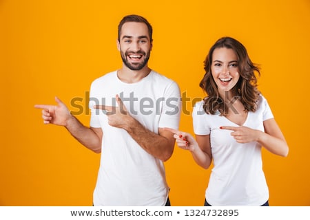 Foto stock: Women Friends Posing Isolated Over Yellow Background Pointing