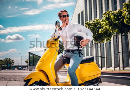 Stok fotoğraf: Portrait Of Stylish Man 20s Sitting On Scooter In City Street A