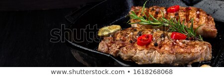 Foto stock: Banner With Grilled Pork Steak In Grill Pan With Rosemary Pepper Chilli And Ginger On Wooden Board