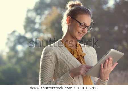 Foto d'archivio: Beautiful Woman With Tablet Computer In Park