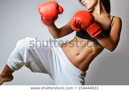 Stock fotó: Beautiful Woman Is Boxing On Gray Background