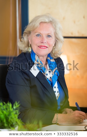 Foto d'archivio: Experienced Receptionist Writing Behind A Front Office Desk