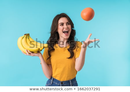 Zdjęcia stock: Happy Pretty Woman Posing Isolated Over Blue Wall Background With Orange Citrus