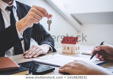 Foto stock: Estate Agent Giving House Keys Customer Sign Agreement Property