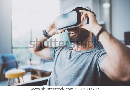 Foto d'archivio: Young Man Wearing Virtual Reality Goggles In Modern Coworking Studio