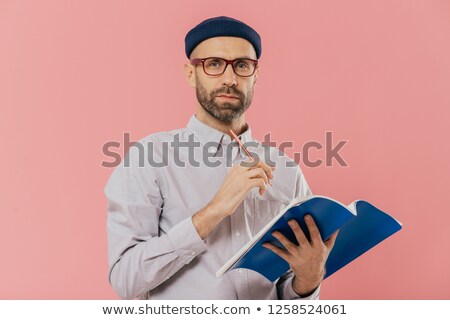Stock fotó: Isolated Shot Of Attractive Young Male Holds Textbook Makes Notes In Organizer Dressed Formally C