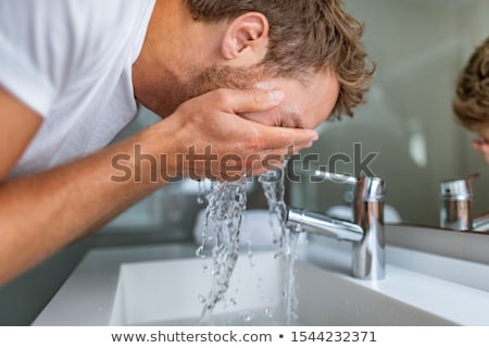 Foto d'archivio: Man Washing Face In Bathroom