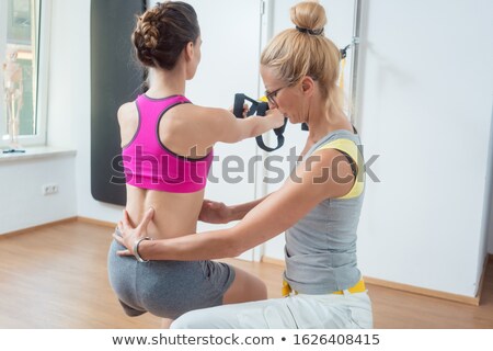 [[stock_photo]]: Woman Using Sling Trainer During Physical Therapy