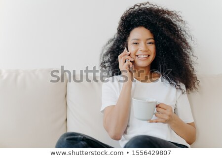 Foto stock: Horizontal Shot Of Good Looking Woman Has Distant Conversation Via Mobile Phone Solves Informal Iss