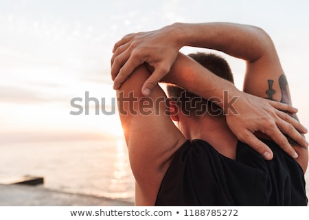 Stockfoto: Sportsman Outdoors At The Beach Make Stretching Exercises