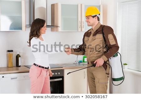 Stockfoto: Woman And Pest Control Worker Shaking Hands