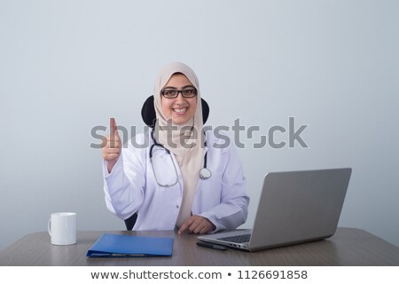 Сток-фото: Doctor Sitting At Her Desk With Laptop And Files