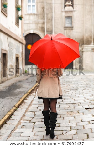 Stockfoto: Woman With Red Umbrella Contemplates On Rain